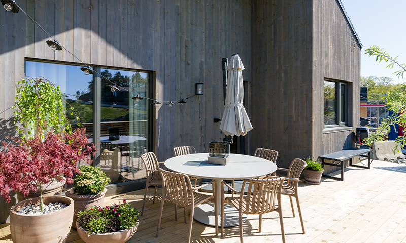 Uteplass på moderne hus med spisegruppe og planter