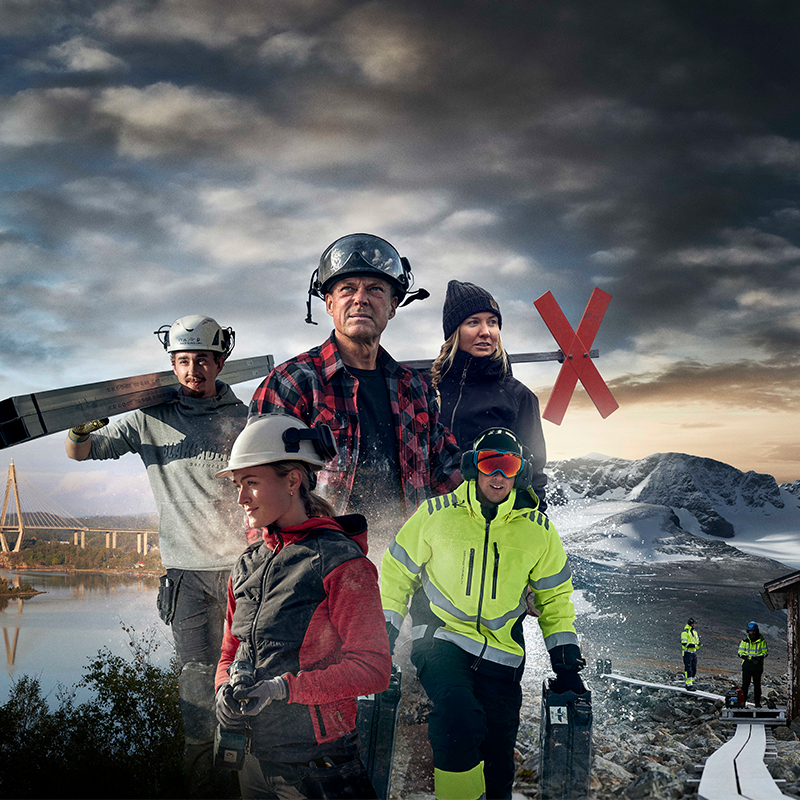 Fem byggearbeidere i vernehjelmer og lysende jakker foran fjord, bru og vinterfjell.