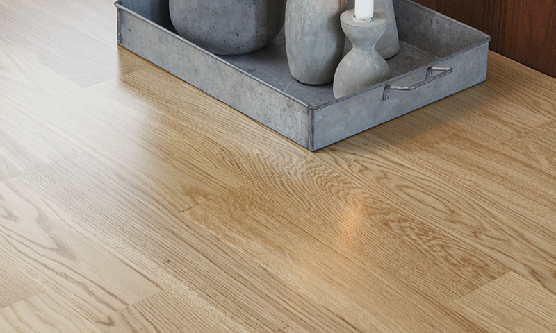 Galvanisert metallbrett med grå sementvaser og hvitt stearinlys på lyst eikebord.