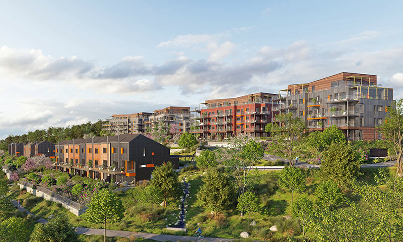 Moderne grå og røde boligblokker og rekkehus på grønn skråning under blå himmel.