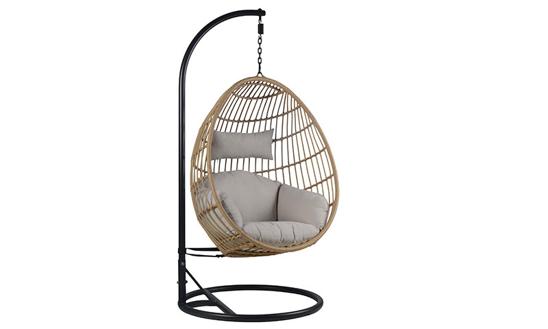 Hengestol i flettet rotting med beige pute på svart metallstativ.