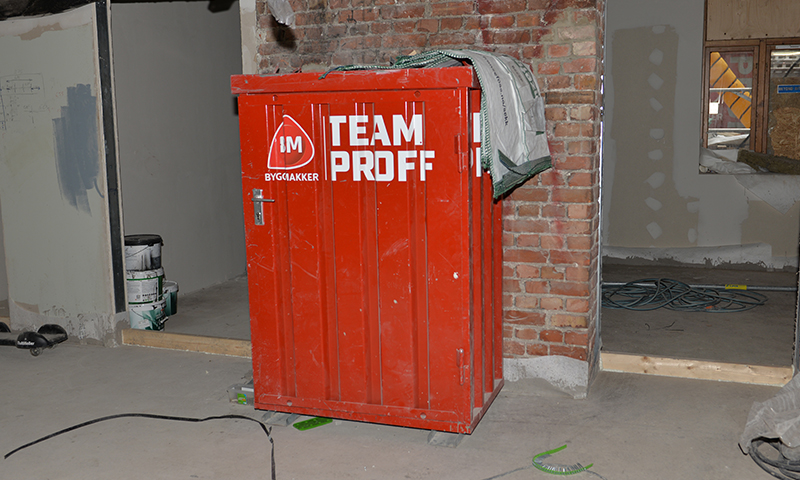 Rødt Team Proff-verktøyskap foran uferdig murvegg på byggeplass.