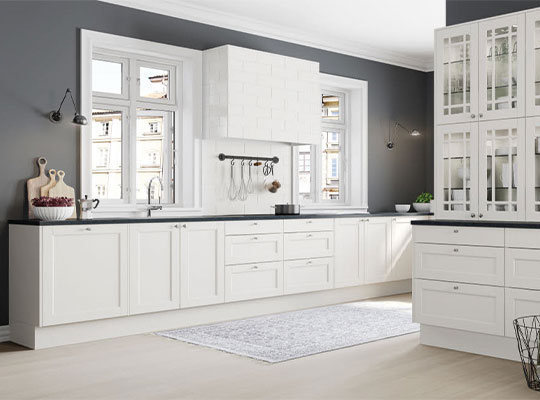 Lys, moderne kjøkken med hvite skapfronter, mørkegrå vegger, svarte benkeplater og store vinduer.