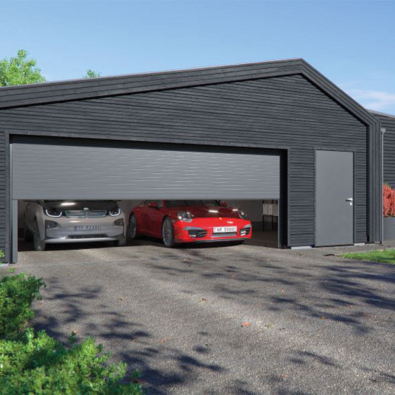 Mørkegrå dobbelgarasje med åpen port, avdekker sølv elbil og rød sportsbil på grusvei.