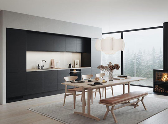 Minimalistisk kjøkken med mørke skap, lyst tregulv, lyst spisebord og stort vindu mot skog