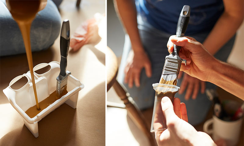 Malekost dyppet i varm brun maling i hvit plastbeholder, to personer i bakgrunnen.