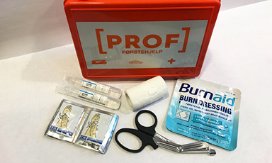 Rødt PROFF førstehjelpsskrin med saks, pincett, bandasjer og brannsårkompresser