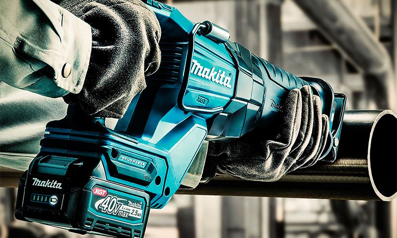 Blå Makita XGT 40V bajonettsag med batteri skjærer metallrør i industrimiljø