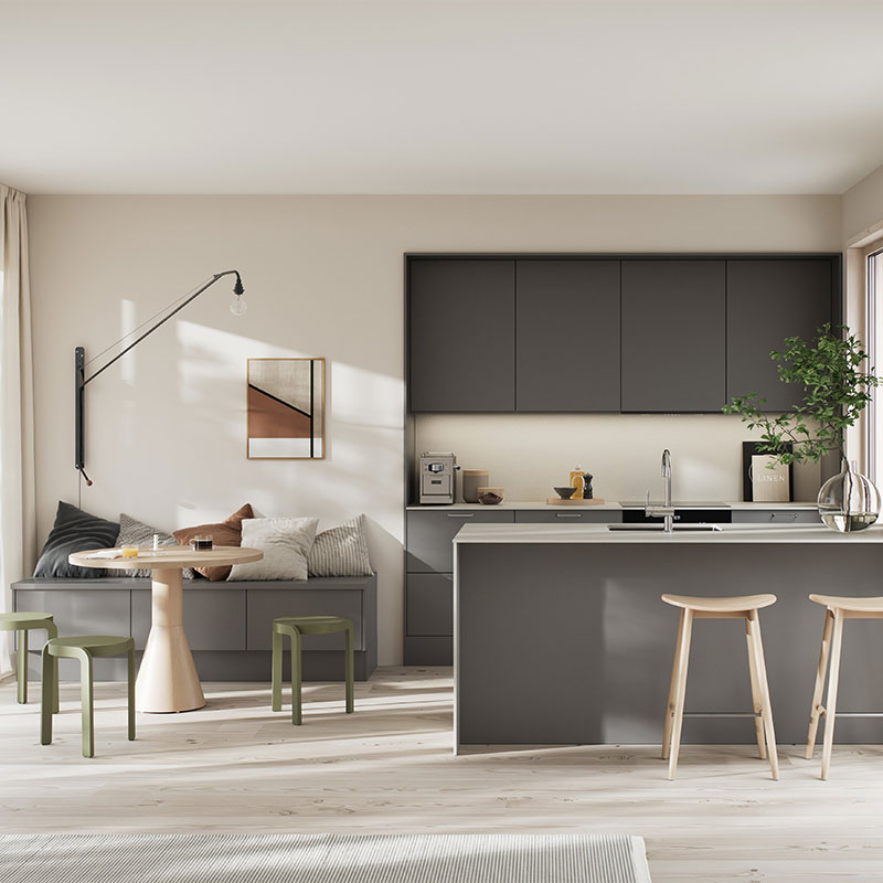 Åpent kjøkken/stue med grå kjøkkenøy, lyst tregulv, benk med puter og grønne krakker.