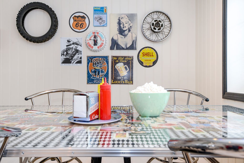 Retro glassbord med grønn bolle popcorn, ketchup- og sennepsflaske, vegg med dekk, felg og bensinskilt