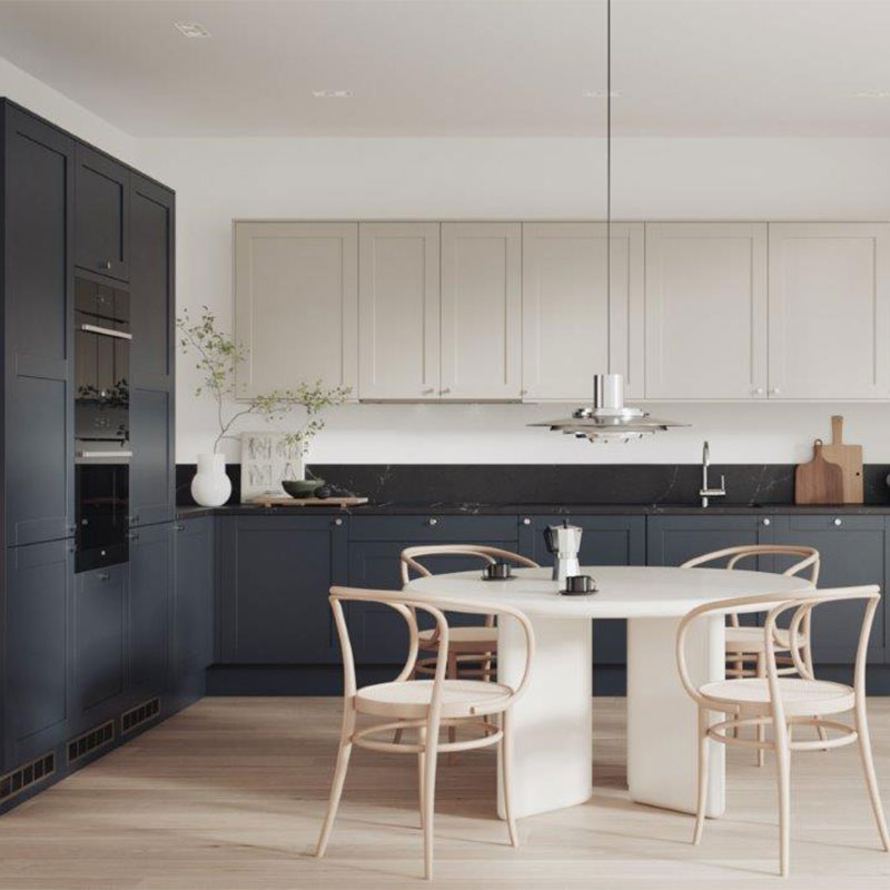 Moderne kjøkken med mørkeblå underskap, lyse overskap, hvitt rundt bord og lyse trestoler.