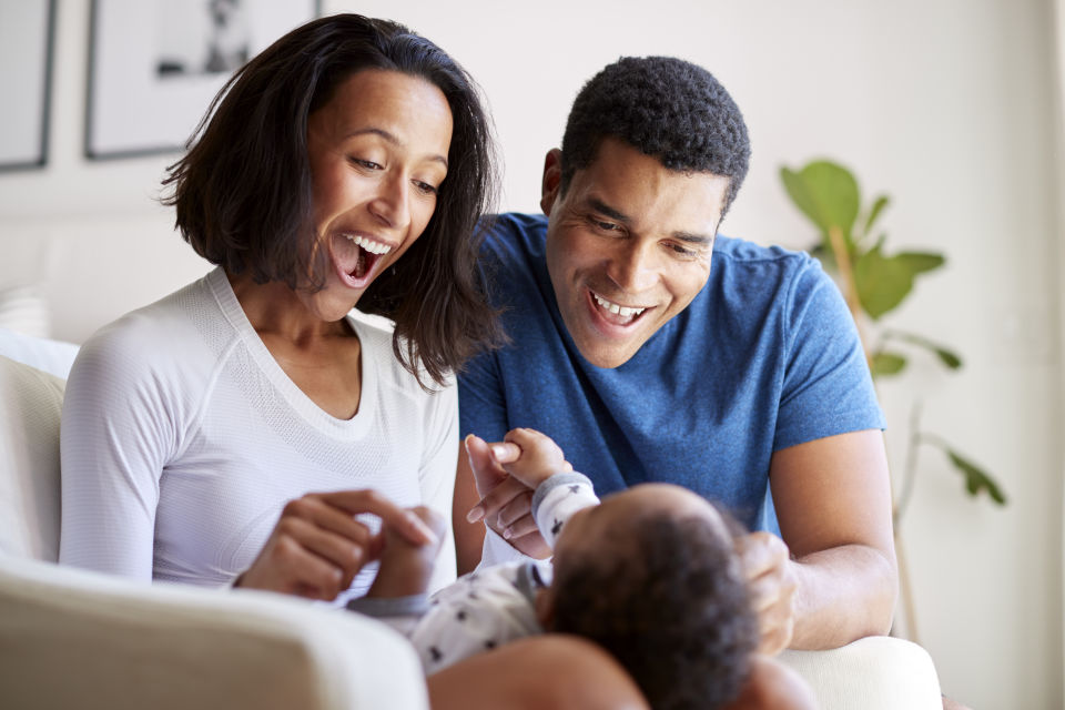 Father wearing blue shirt, baby in mothers lap