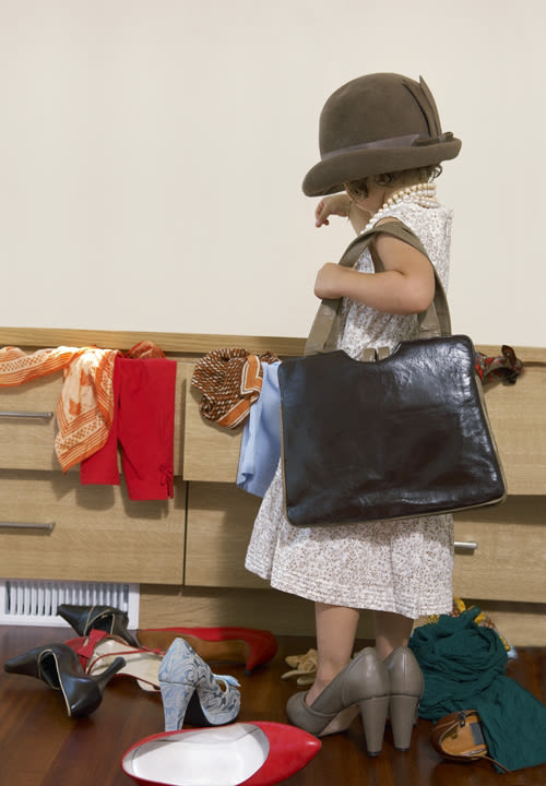 Girl playing dress up with mothers clothes
