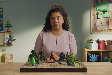 A woman standing in front a childs toy.