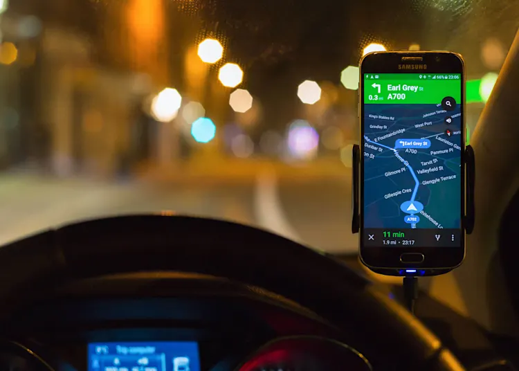 Using smartphone SatNav at night for driving directions.