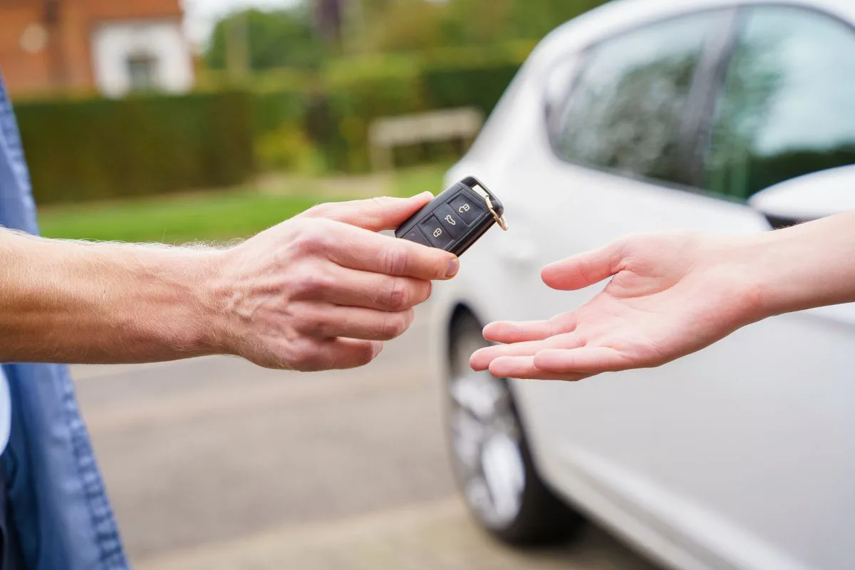 Man hans over car keys to trusted garage to have his MOT test done