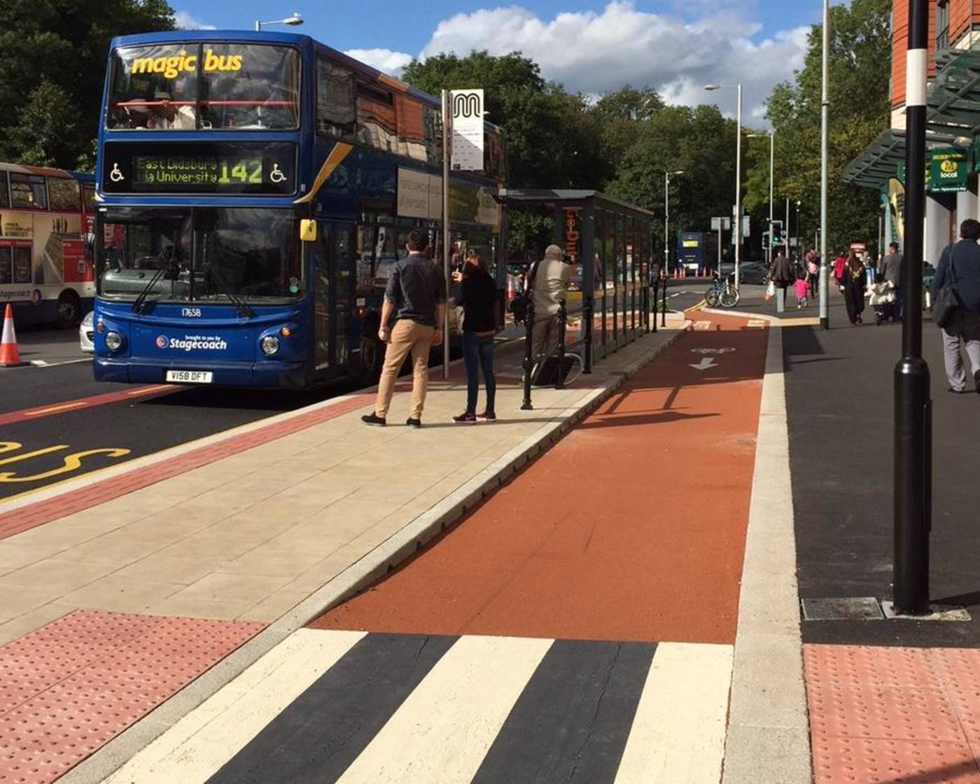 An image showing a bus stop bypass with passengers waiting to get on a bus