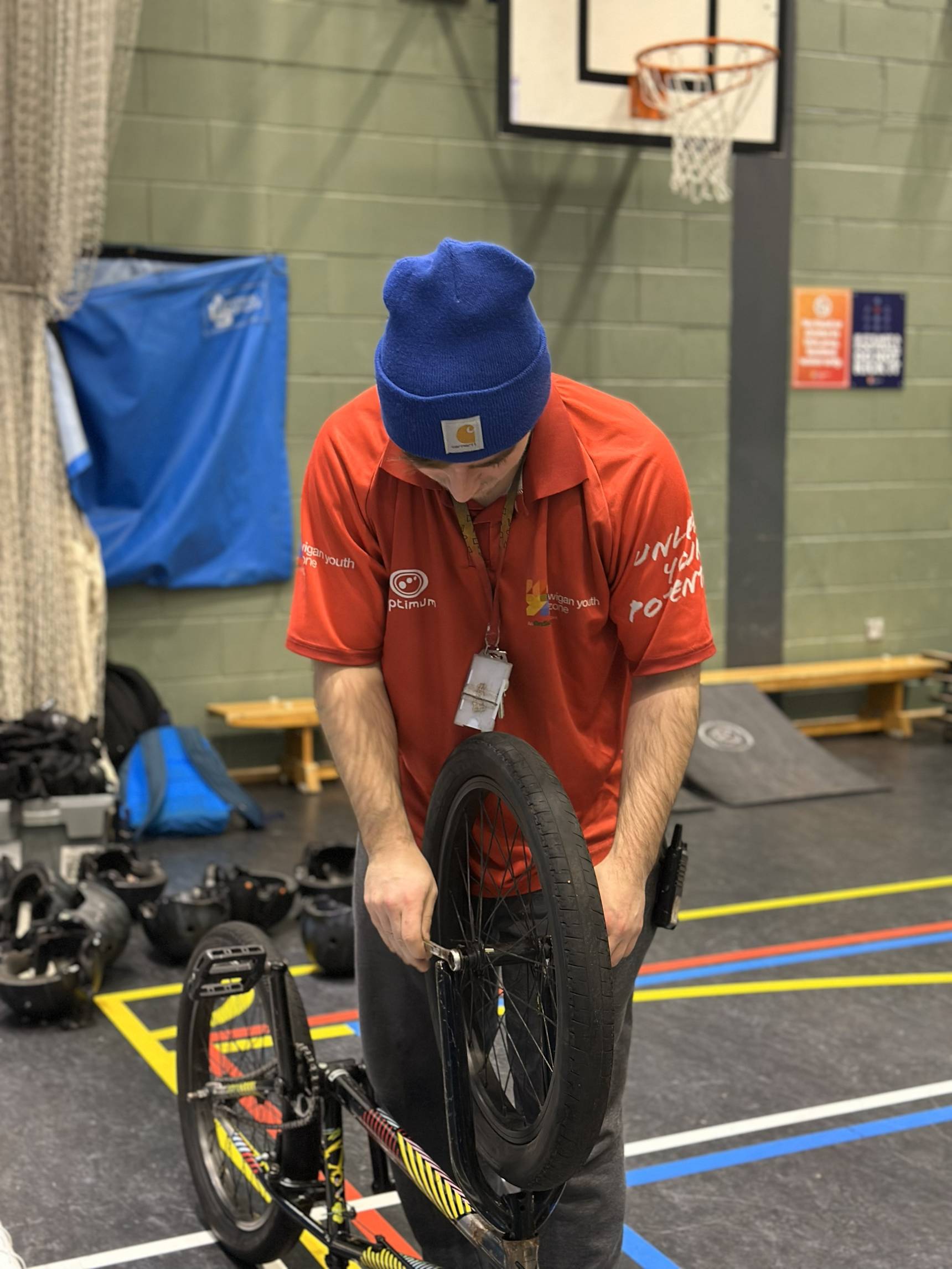 Wigan Youth Zone worker fixing a bike