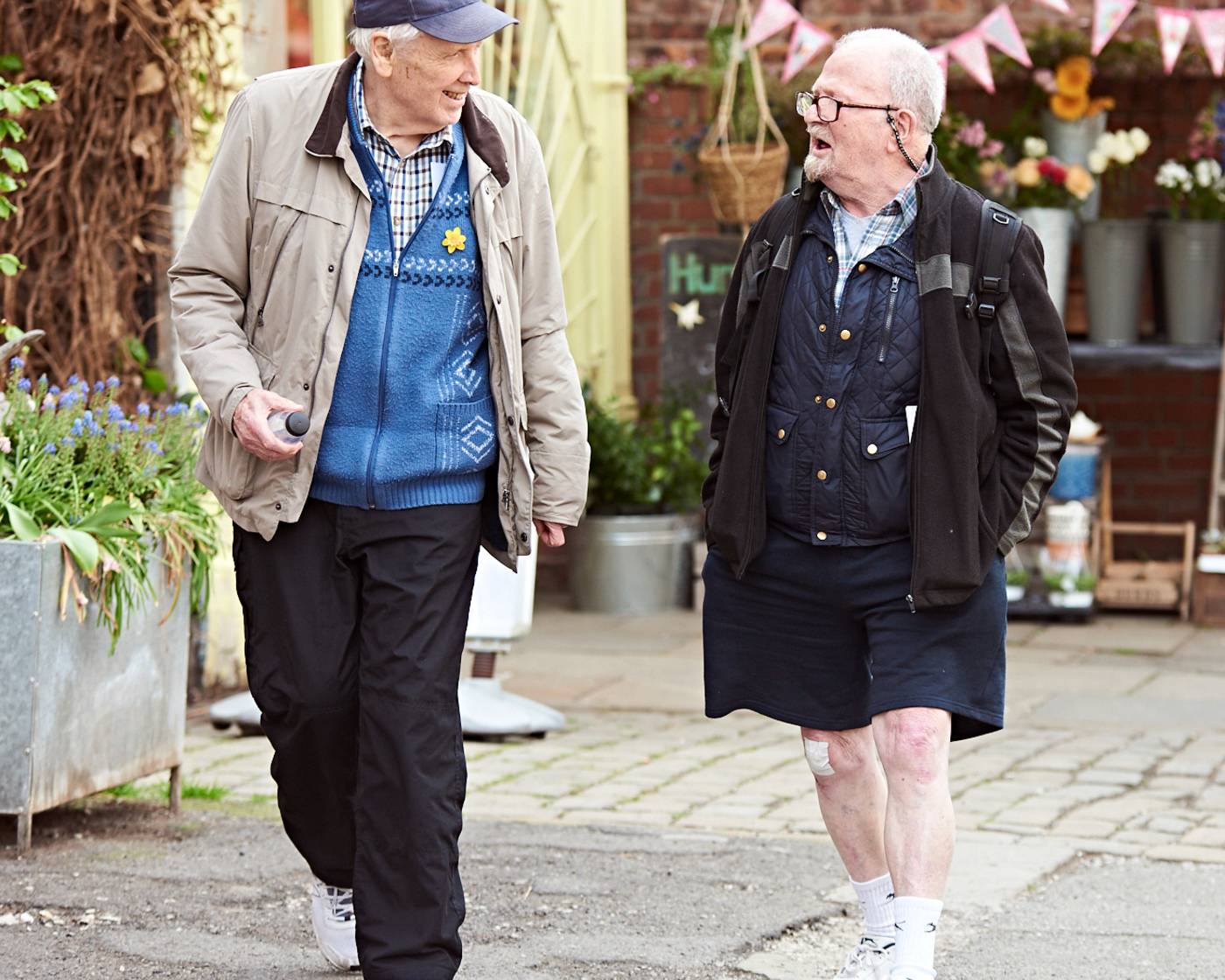 Two older men walking along a pedestrianised street