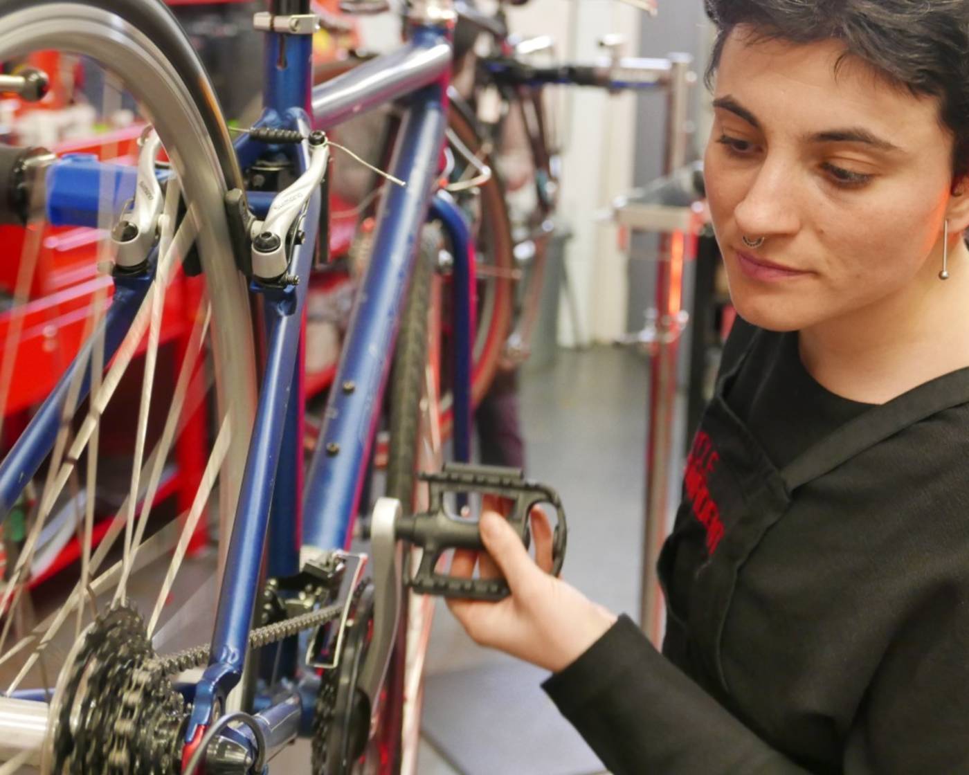 Close up of a woman fixing bike pedals at a women's only maintenance course