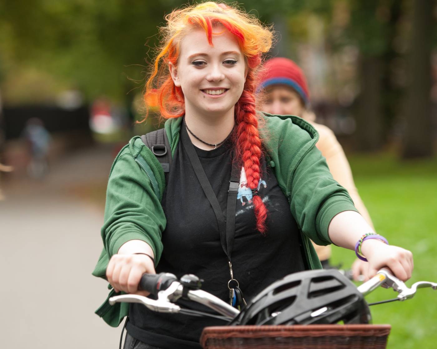 Red haired woman smiling on a bike with a basket