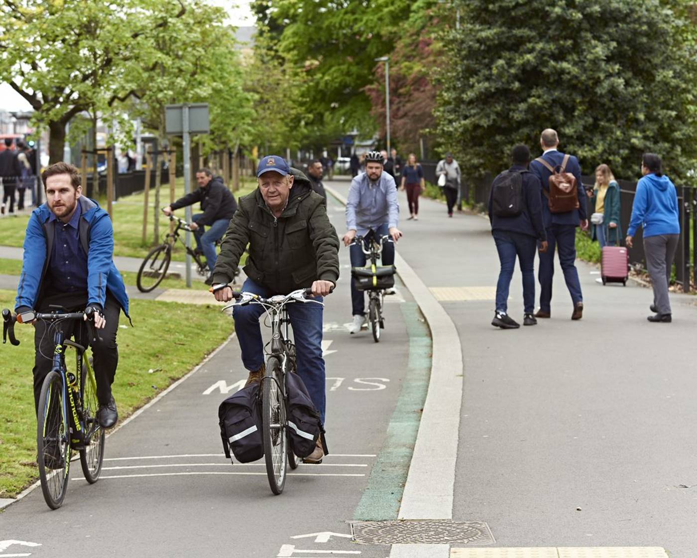 An image of a street with multiple people cycling in the cycle lane