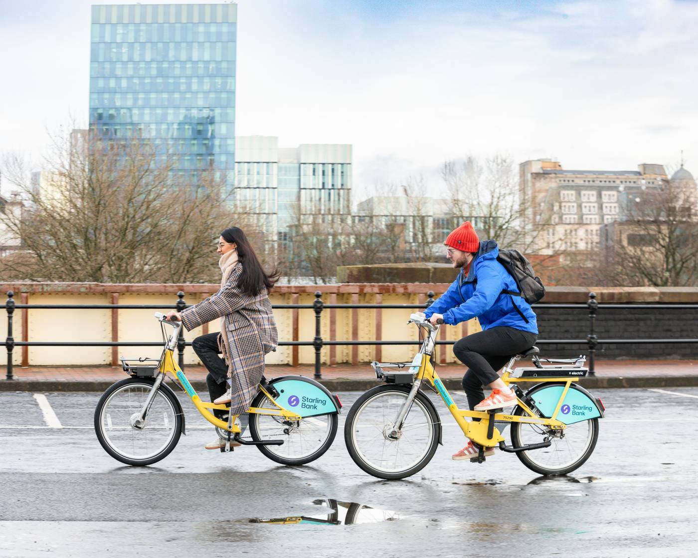 Two people riding Starling Bank Bikes in Manchester