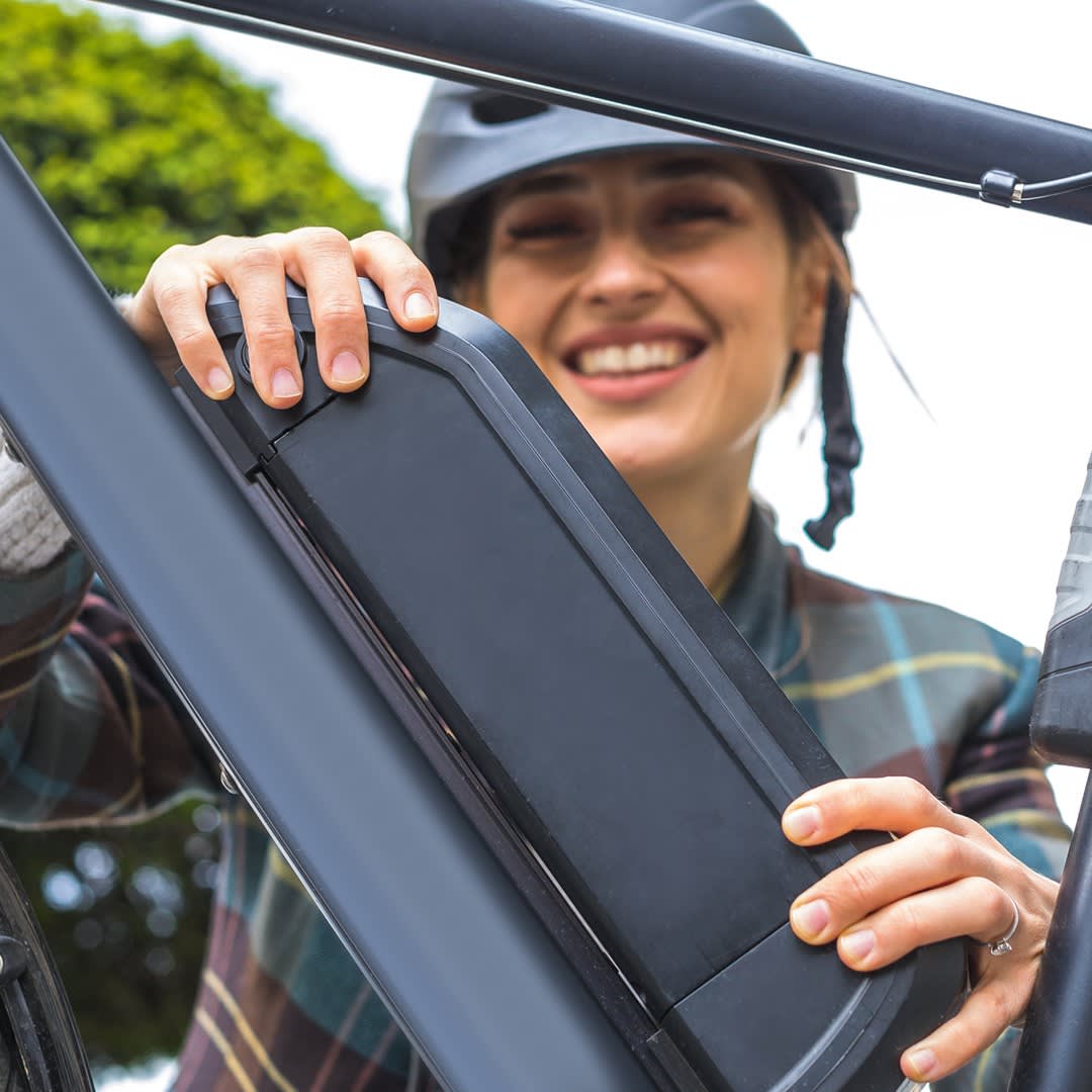 person checking battery on ebike