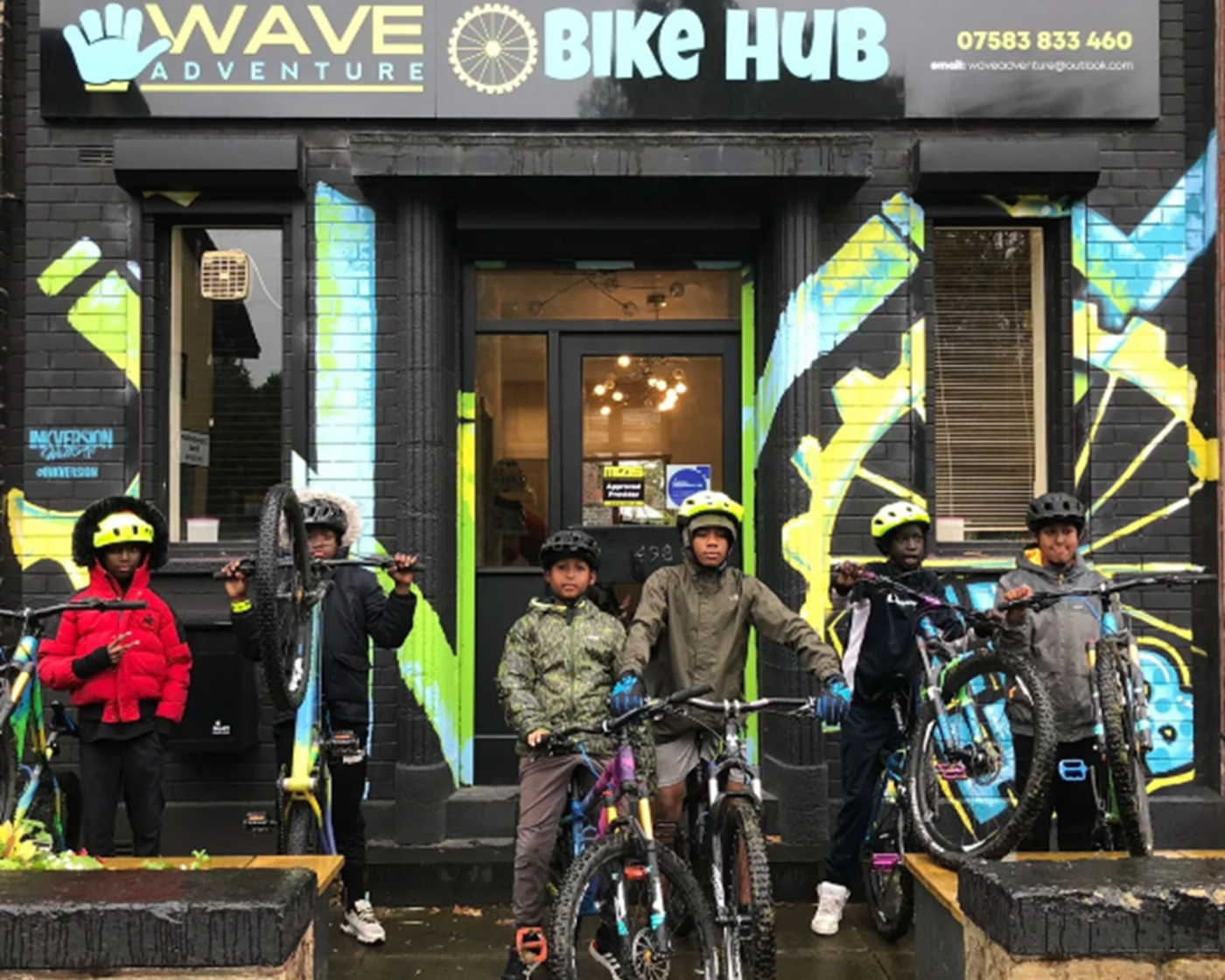 Group of young people outside of the wave adventures hub on bikes