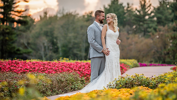 Bride and groom smiling at one another in the flower hole at the SentryWorld golf course