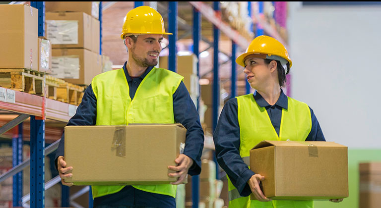 Man and woman in hard hats carrying boxes