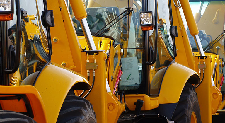 Large yellow industrial machines parked in a line.