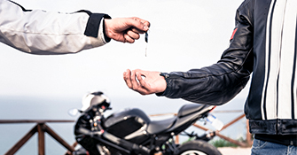 Man giving keys to motorcycle to another man