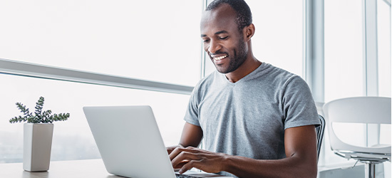 Man typing on a laptop computer in an office