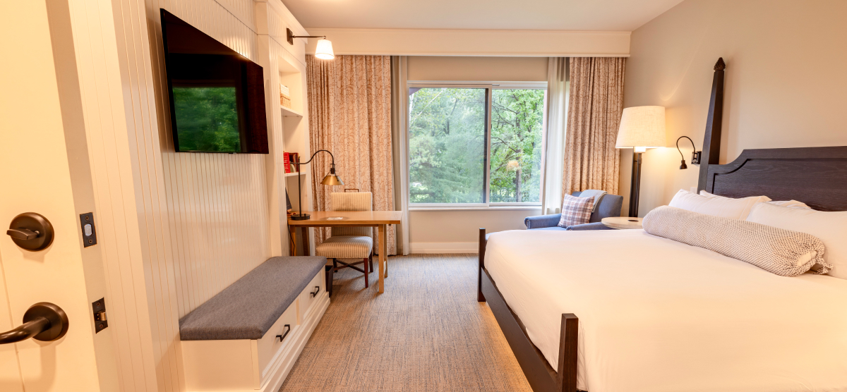 Hotel room with king sized bed and desk area. 