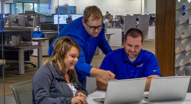 Three people working together in a conference room at Sentry Home Office.