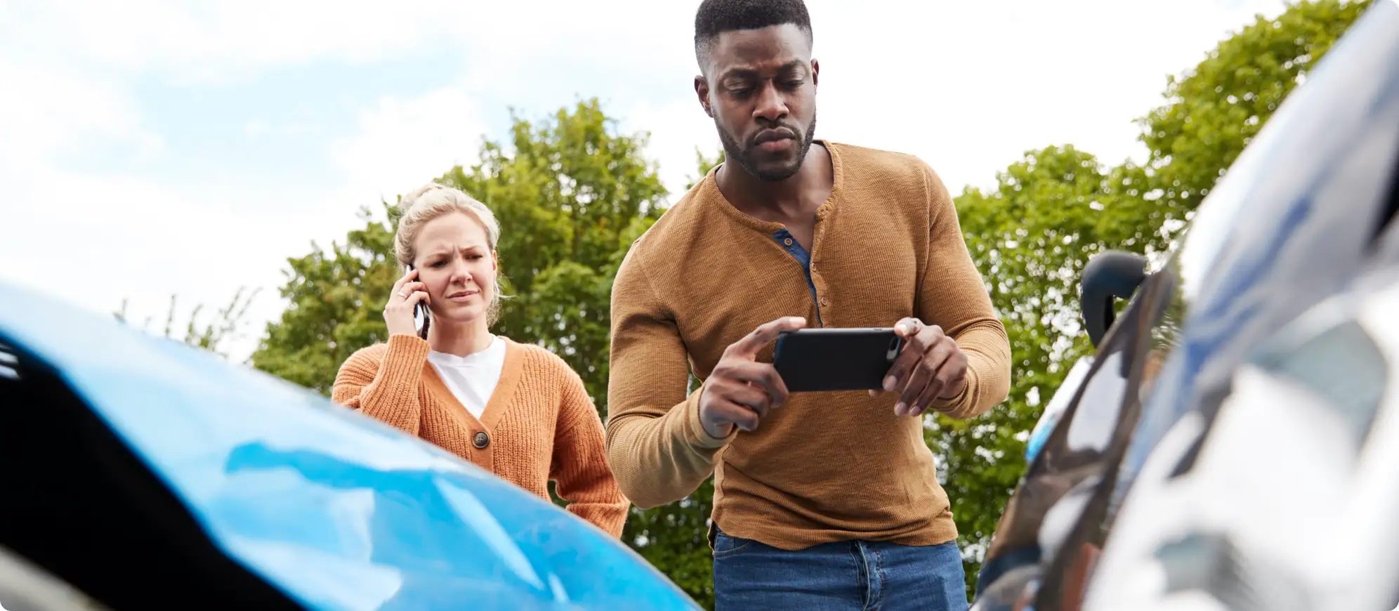 Man and woman taking photos of a fender bender