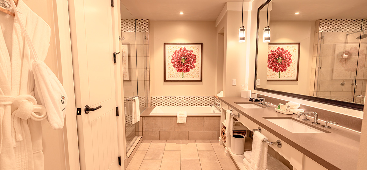 carousel-executive-junior-suite-3-1200x556 Bathroom with sinks, tub and bathrobe.
