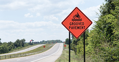 Grooved pavement road sign near highway