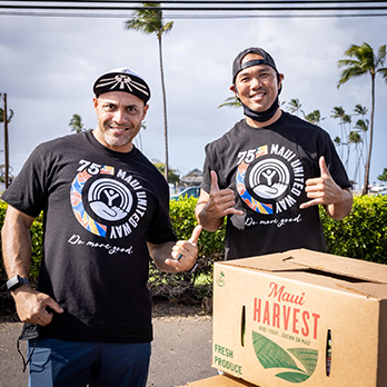 Two men standing by boxes of food