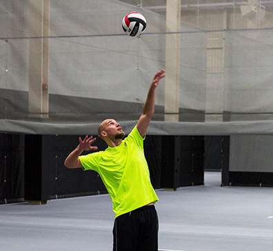 Player serving a volleyball in the SentryWorld fieldhouse