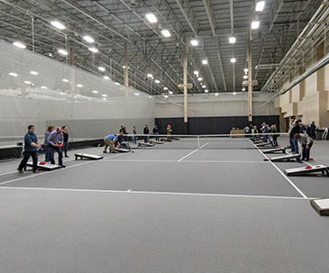 Teams playing a game of bean bag toss on the courts in the SentryWorld fieldhouse