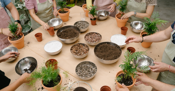 a group of people each potting a plant