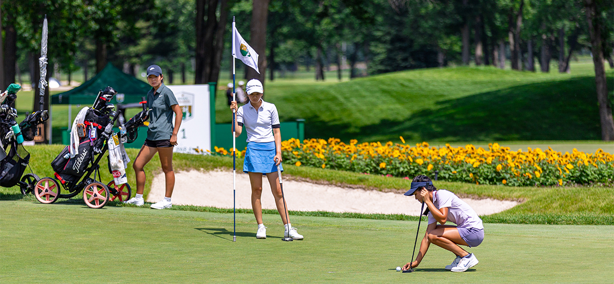 Three junior girls putting on hole 16. 