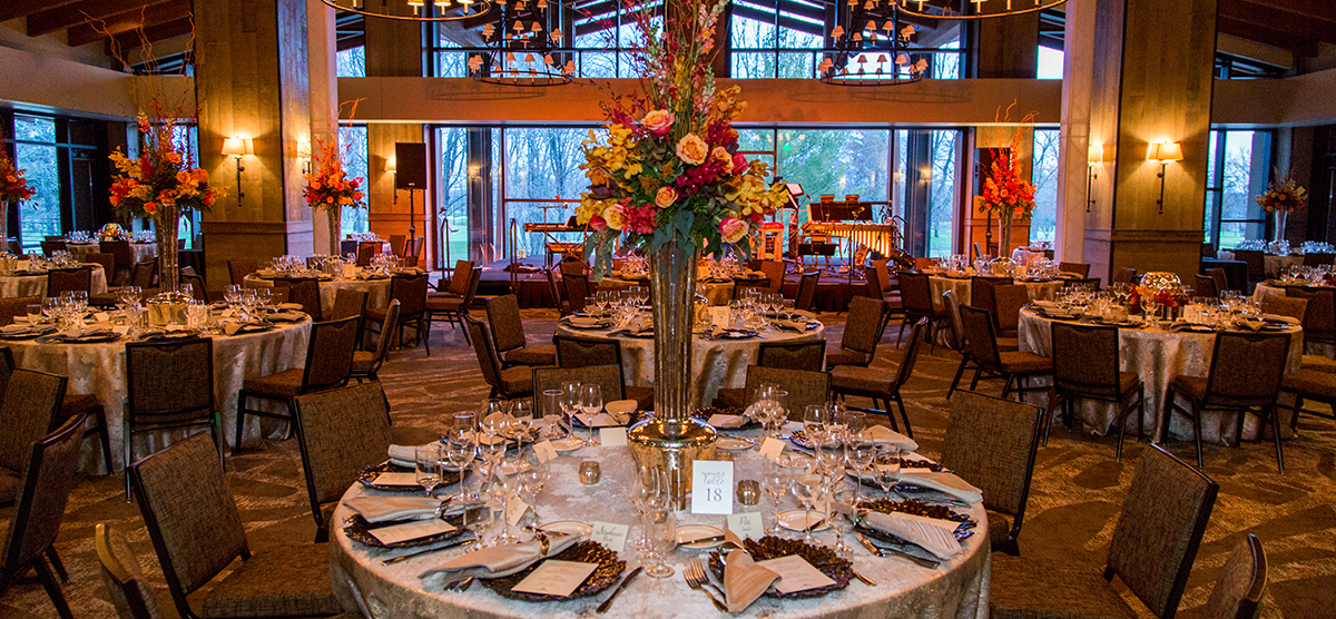 Tables and floral centerpieces set for a wedding reception in the Grand Hall