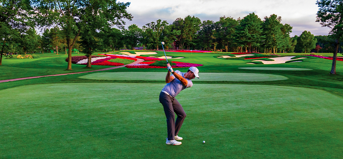 Player teeing off on hole 16 on the SentryWorld golf course