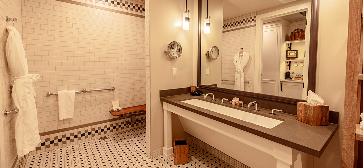 carousel-accessible-golf-view-king-suite-3-1200x556 Bathroom sink with wheelchair space and zero entry shower with grab bars.