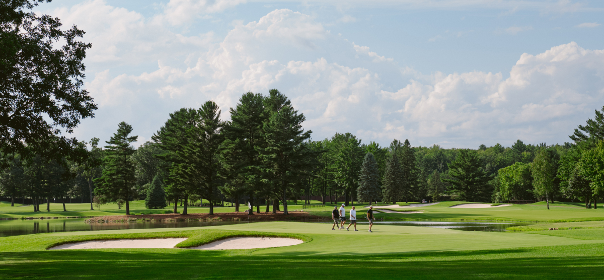 Group of golfers finishing a hole and walking to their cart. 