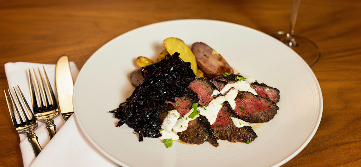 Coffee-rubbed wagyu flat iron steak with braised red cabbage, creme, and roasted potatoes. 