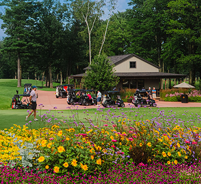hero-tee-times-rates-396x364 Golfers and golf carts at the refreshment station building.
